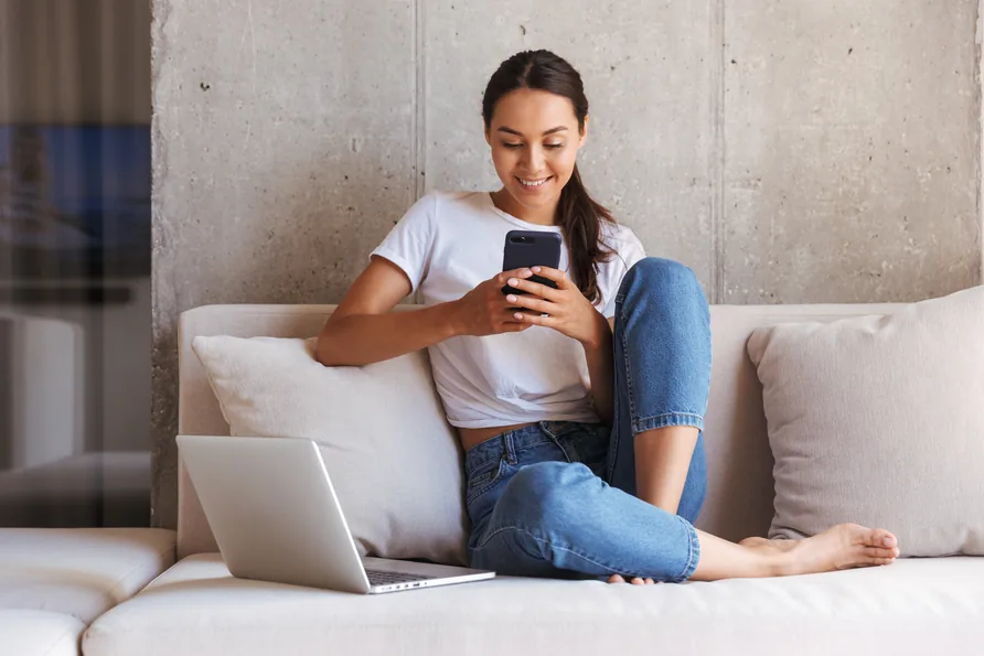 A person setting up a campaign from a laptop and phone at home.